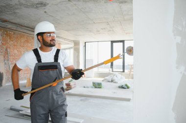 Kızılderili ressam ofis duvarını tekerlekli boyayla boyuyor..