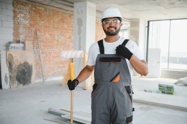 Kızılderili ressam ofis duvarını tekerlekli boyayla boyuyor..