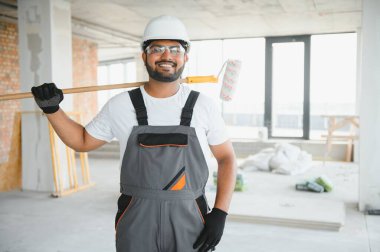 Kızılderili ressam ofis duvarını tekerlekli boyayla boyuyor..