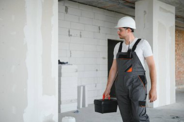 İnşaat sektöründe çalışan yakışıklı işçinin portresi.