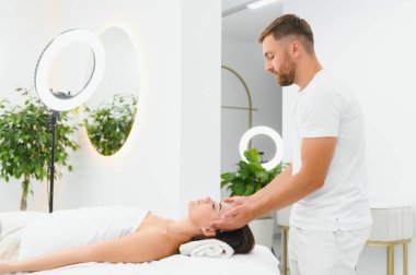 Genç bir kadın masaj salonundan zevk alıyor. Yüz masajı.