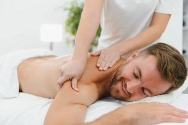 Yakışıklı orta yaşlı adam yağlı spa masajından zevk alıyor..