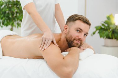 Yakışıklı orta yaşlı adam yağlı spa masajından zevk alıyor..