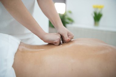 Genç bir adam profesyonel bir masöz tarafından masaj yaptırıyor..