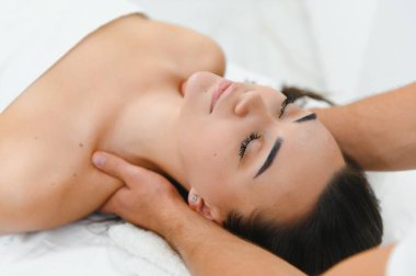 Genç bir kadın masaj salonundan zevk alıyor. Yüz masajı.