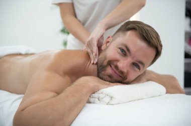 Yakışıklı orta yaşlı adam yağlı spa masajından zevk alıyor..