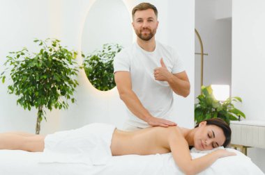 Osteopat, kaplıcada kadının sırtına masaj yapıyor..