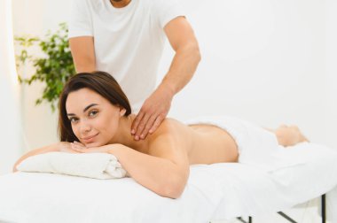 Spa terapisi. Güzeller güzeli genç bayan masaj sırasında masaya uzanıyor, yakın plan..