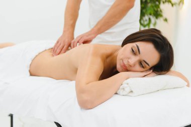 Spa terapisi. Güzeller güzeli genç bayan masaj sırasında masaya uzanıyor, yakın plan..