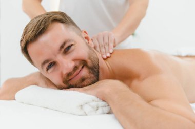 Genç bir adam profesyonel bir masöz tarafından masaj yaptırıyor..