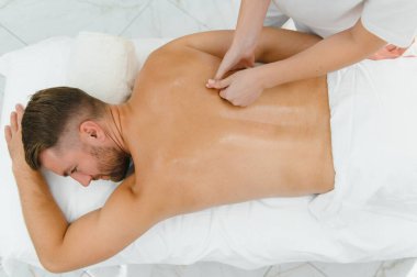 Yakışıklı orta yaşlı adam yağlı spa masajından zevk alıyor..