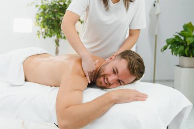 Yakışıklı orta yaşlı adam yağlı spa masajından zevk alıyor..