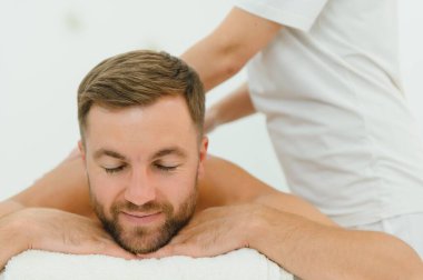 Yakışıklı orta yaşlı adam yağlı spa masajından zevk alıyor..