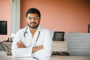 Genç Hintli profesyonel doktor steteskoplu beyaz üniforma giyiyor..