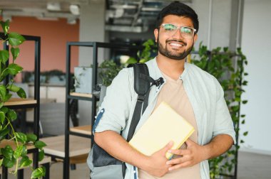 Üniversitedeki mutlu Hintli erkek öğrenci.