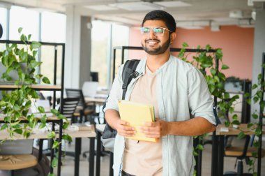 Üniversitedeki mutlu Hintli erkek öğrenci.