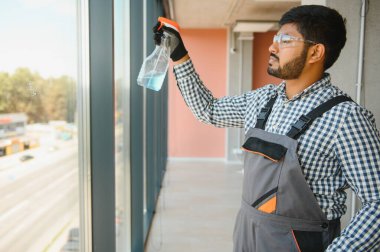 Pencereleri temizleyen bir adam. Erkekler camları siler..