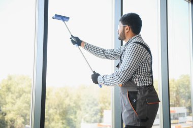 Pencereleri temizleyen bir adam. Erkekler camları siler..