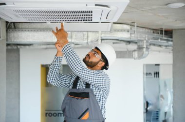 Uzman havalandırmayı tamir ediyor..