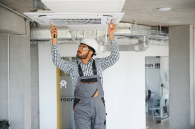 Uzman havalandırmayı tamir ediyor..