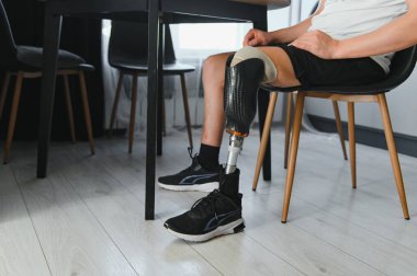 Evinde biyonik protez bacağı olan tanınmayan bir adamın yakın plan fotoğrafı..