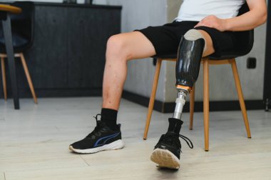 Evinde protez bacak sakatlığı olan bir adam bacak transfemoral protezi takıyor. Ampütasyon engelli insanlar günlük hayatta.