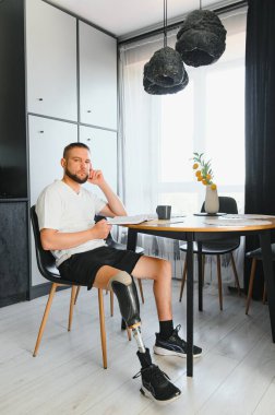 Evinde protez bacak sakatlığı olan bir adam bacak transfemoral protezi takıyor. Ampütasyon engelli insanlar günlük hayatta.
