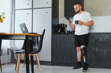 Evinde protez bacak sakatlığı olan bir adam bacak transfemoral protezi takıyor. Ampütasyon engelli insanlar günlük hayatta.