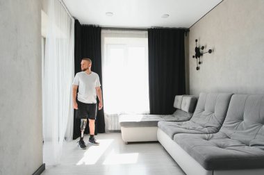 Evinde protez bacak sakatlığı olan bir adam bacak transfemoral protezi takıyor. Ampütasyon engelli insanlar günlük hayatta.