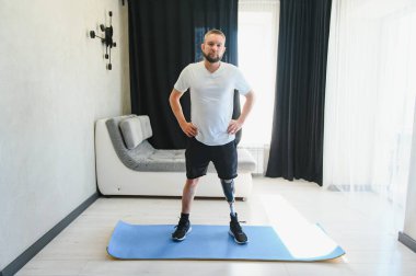 Adam internette egzersiz yapıyor. Bacağı kesilmiş, evde bacaklarını esnetiyor..