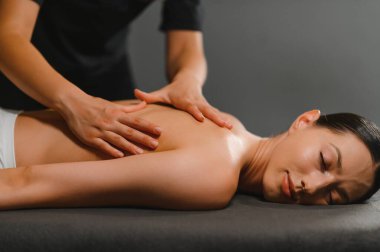 Masör spa salonundaki kadına masaj yapıyor..