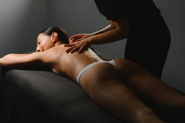 Vücut masajı. Spa salonunda masaj yaptıran bir kadın. Masör sırtında çalışıyor..