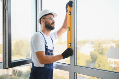 İçeriye plastik pencere kuran işçiler.