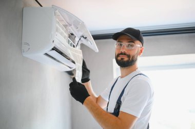 Tamirci havalandırma sistemlerini tamir eder, havalandırmaların onarımı ve bakımı için erkek teknisyenler, havalandırma teknisyenleri evlere yeni klimalar kurar.