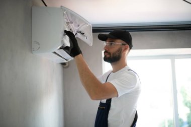 Tamirci havalandırma sistemlerini tamir eder, havalandırmaların onarımı ve bakımı için erkek teknisyenler, havalandırma teknisyenleri evlere yeni klimalar kurar.