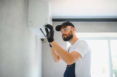 Tamirci havalandırma sistemlerini tamir eder, havalandırmaların onarımı ve bakımı için erkek teknisyenler, havalandırma teknisyenleri evlere yeni klimalar kurar.
