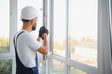 Yükleme penceresi içinde ev inşaat işçisi. Tornavida ile pencereyi tamir tamirci.
