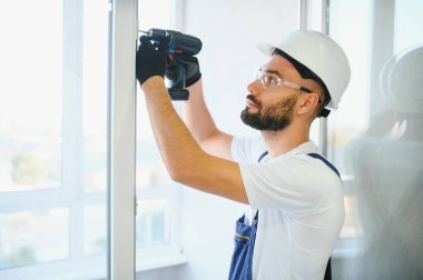 İçeriye plastik pencere kuran işçiler.