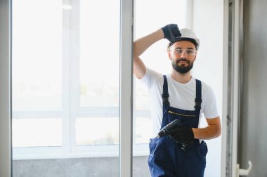 İçeriye plastik pencere kuran işçiler.