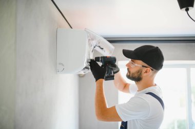 Tamirci havalandırma sistemlerini tamir eder, havalandırmaların onarımı ve bakımı için erkek teknisyenler, havalandırma teknisyenleri evlere yeni klimalar kurar.