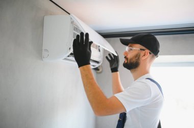 Tamirci havalandırma sistemlerini tamir eder, havalandırmaların onarımı ve bakımı için erkek teknisyenler, havalandırma teknisyenleri evlere yeni klimalar kurar.