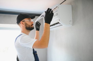 Tamirci havalandırma sistemlerini tamir eder, havalandırmaların onarımı ve bakımı için erkek teknisyenler, havalandırma teknisyenleri evlere yeni klimalar kurar.