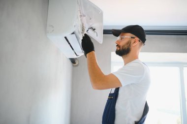 Tamirci havalandırma sistemlerini tamir eder, havalandırmaların onarımı ve bakımı için erkek teknisyenler, havalandırma teknisyenleri evlere yeni klimalar kurar.