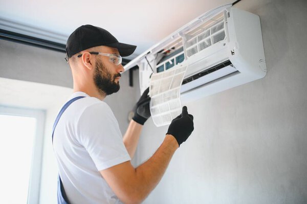 Repairman fix air conditioning systems, Male technicians service for repair and maintenance of air conditioners, Air conditioning technicians install new air conditioners in homes.