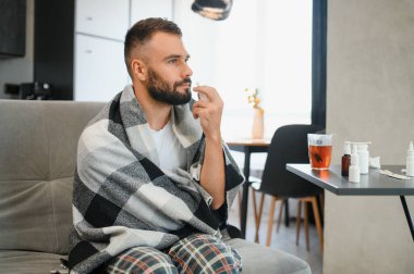 İnsanlar ve sağlık sorunu kavramı. Burnuna burun spreyi sıkan hasta adama yakın çekim..