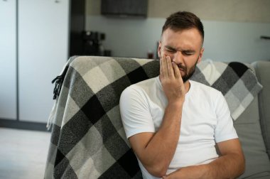 Genç adam evinde diş ağrısı çekiyor..