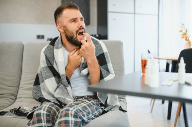 Genç adam evde boğaz spreyi kullanıyor..