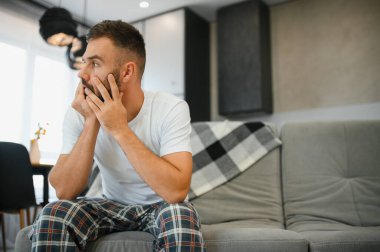 Genç adam akşamdan kalma halinin ertesi sabahı şiddetli baş ağrısı ya da migrenden muzdarip..