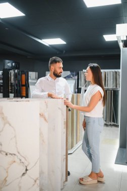 Satıcı ve bayan bir müşteri evi için seramik bir fayans seçiyorlar, ev tasarımı mağazasında..