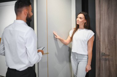 Hırdavatçı, kadın müşteri iç kapıları seçer..